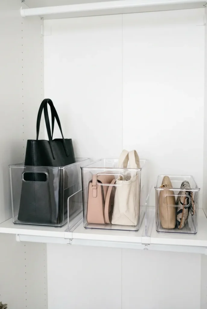 Clear bins with acrylic shelf dividers for purse storage ideas showing bags sorted by size on white closet shelf